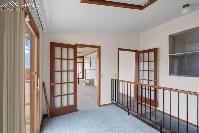 hallway featuring carpet floors, french doors, and vaulted ceiling