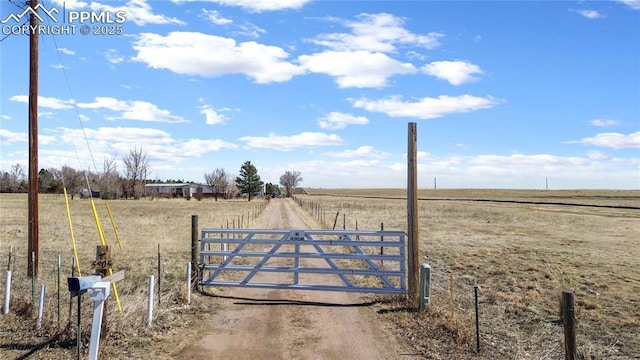 view of gate featuring a rural view and fence