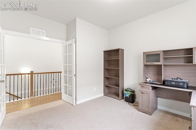 office space featuring light carpet, french doors, and visible vents