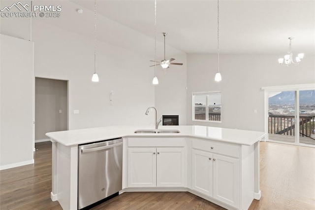 kitchen featuring light countertops, open floor plan, a sink, light wood-type flooring, and dishwasher