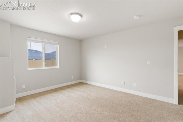 unfurnished room with light carpet and baseboards