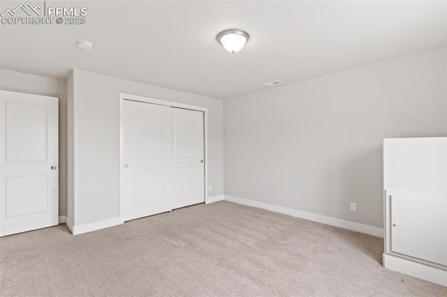 unfurnished bedroom featuring a closet, carpet flooring, visible vents, and baseboards