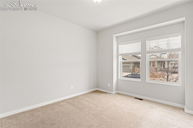 empty room with carpet flooring, visible vents, and baseboards