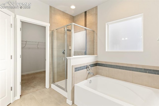 full bath featuring a garden tub, a stall shower, a walk in closet, and tile patterned floors