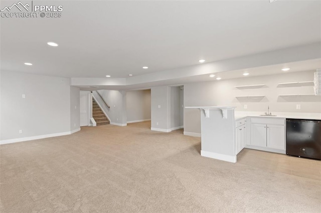 finished basement featuring recessed lighting, light carpet, a sink, stairs, and indoor wet bar