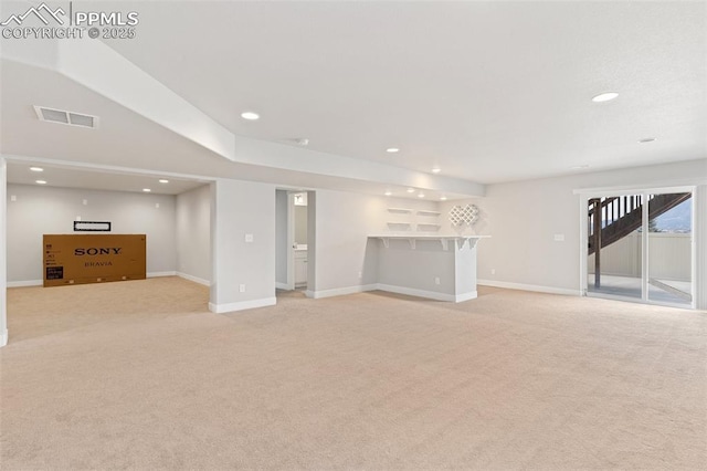 below grade area featuring recessed lighting, light colored carpet, visible vents, baseboards, and a bar