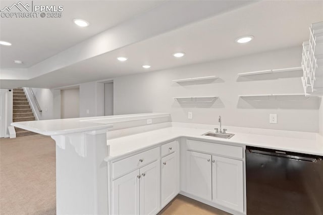 kitchen with dishwashing machine, a peninsula, a sink, white cabinets, and open shelves