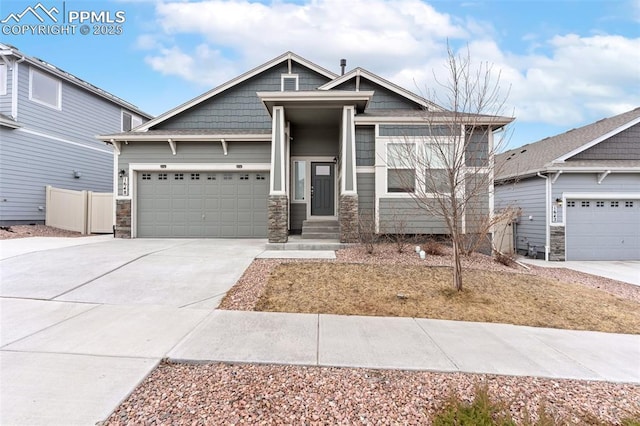 craftsman-style home featuring driveway, stone siding, an attached garage, and fence