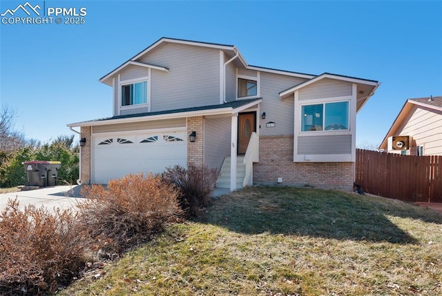 view of front of home featuring brick siding, a front yard, fence, a garage, and driveway