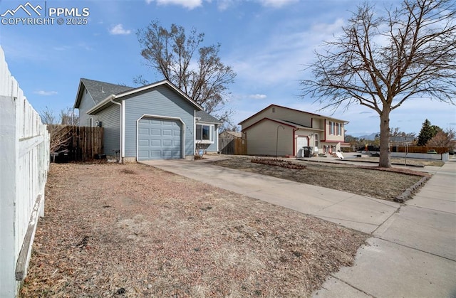 exterior space with driveway, an attached garage, and fence