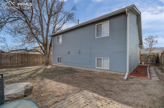 rear view of house featuring a fenced backyard