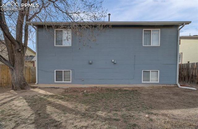 back of property with visible vents and fence