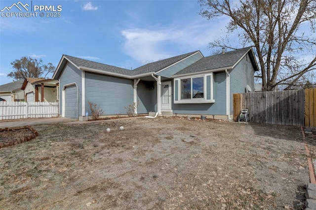 ranch-style home with a garage, roof with shingles, and fence