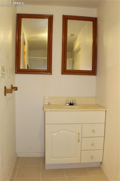 bathroom with tile patterned flooring, vanity, and baseboards