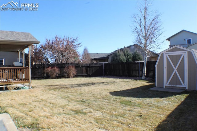 view of yard featuring an outbuilding, a storage shed, and a fenced backyard