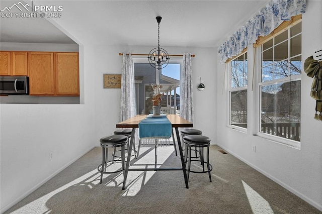 carpeted dining area with visible vents, baseboards, and a notable chandelier