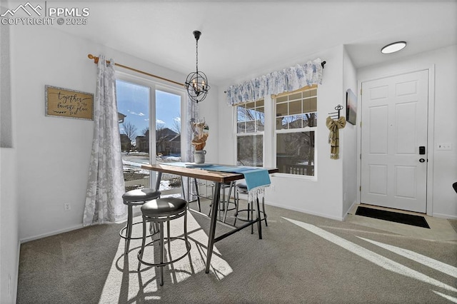 dining space featuring a notable chandelier, carpet floors, and baseboards