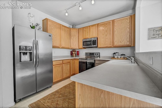 kitchen featuring stainless steel appliances, light countertops, a sink, and light tile patterned floors