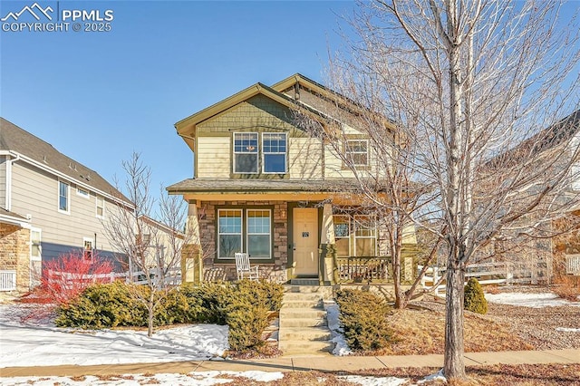 craftsman-style home featuring stone siding and a porch