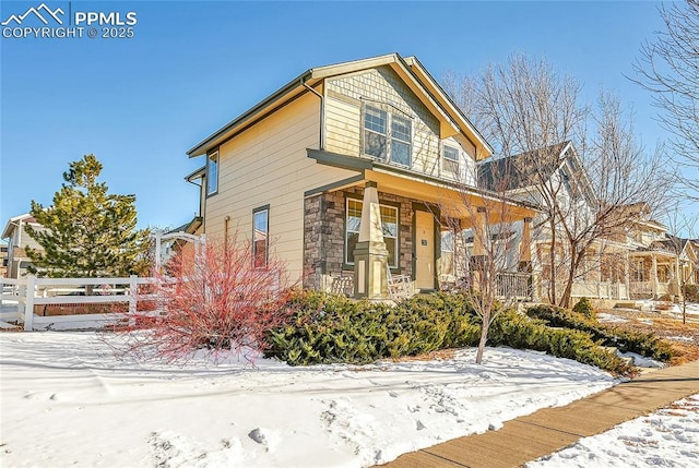 exterior space featuring a porch, stone siding, and fence