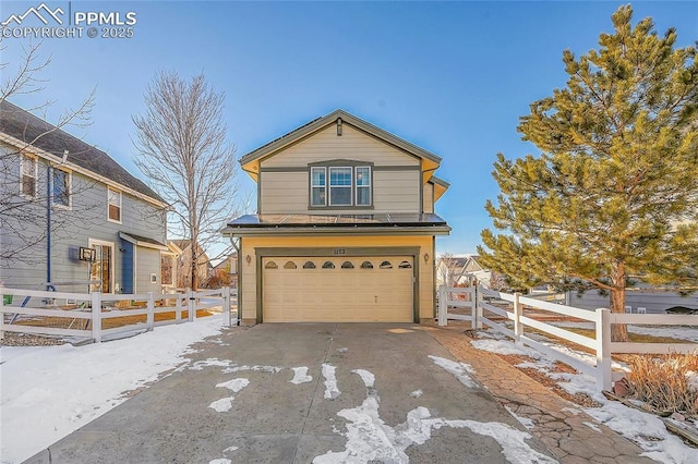 view of front of home with a garage, concrete driveway, and fence