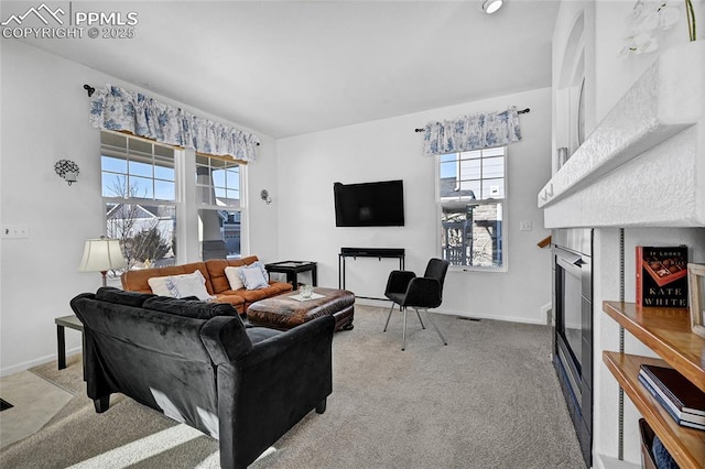 living area featuring carpet floors, a fireplace, and baseboards