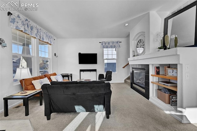 living area with carpet flooring, a tile fireplace, and baseboards