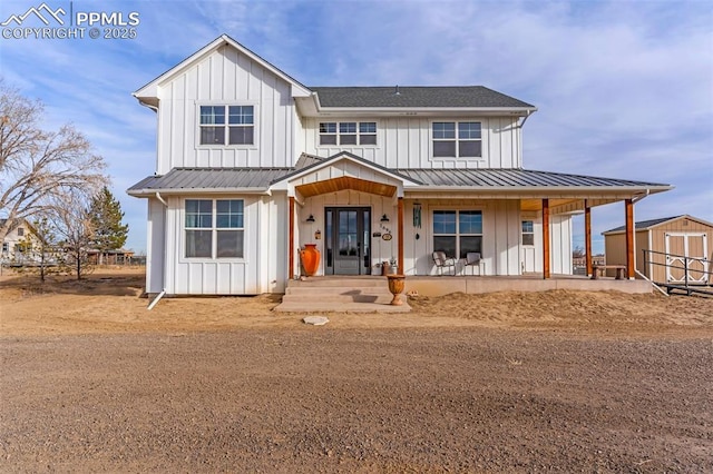 modern farmhouse style home with board and batten siding, an outbuilding, metal roof, and a storage shed