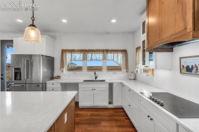 kitchen with high end refrigerator, dark wood-type flooring, black electric stovetop, light countertops, and white cabinetry