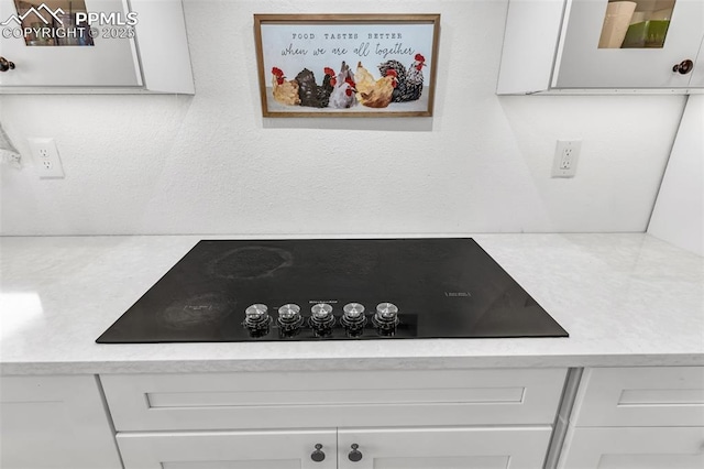 details with white cabinetry and black electric stovetop