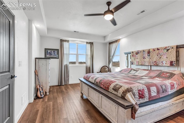 bedroom featuring wood finished floors, visible vents, and baseboards