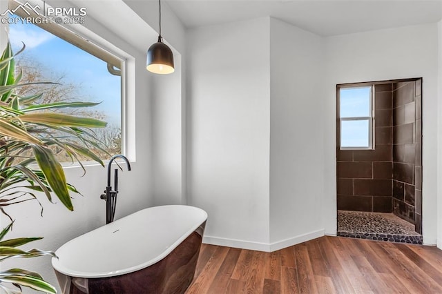 full bathroom featuring a freestanding tub, tiled shower, wood finished floors, and baseboards