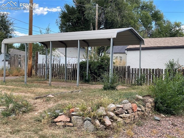 view of yard with a detached carport and fence