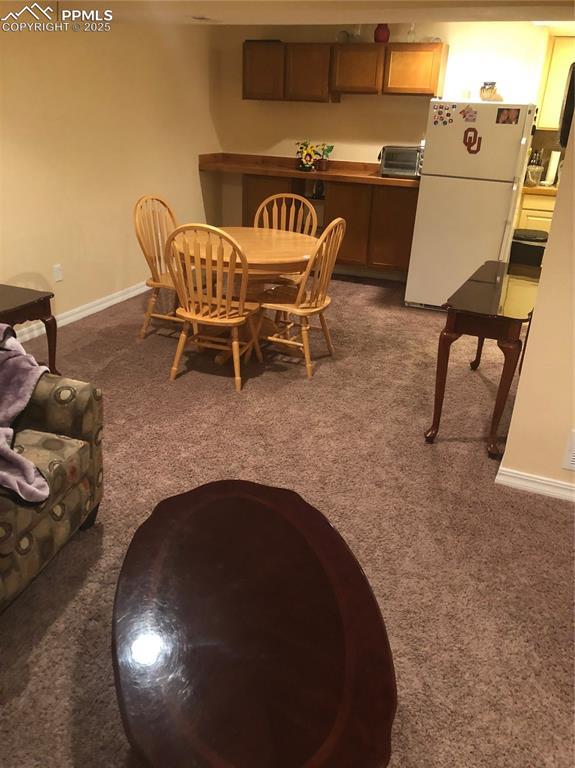 dining room featuring carpet floors, a toaster, and baseboards