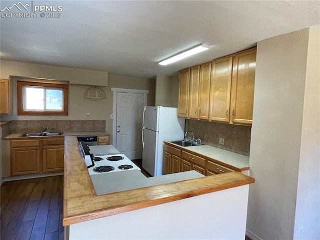 kitchen featuring freestanding refrigerator, light countertops, a sink, and decorative backsplash