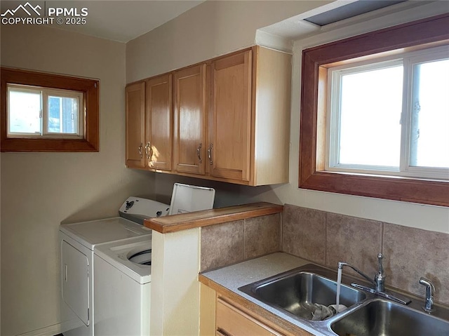 laundry room with cabinet space, a wealth of natural light, separate washer and dryer, and a sink