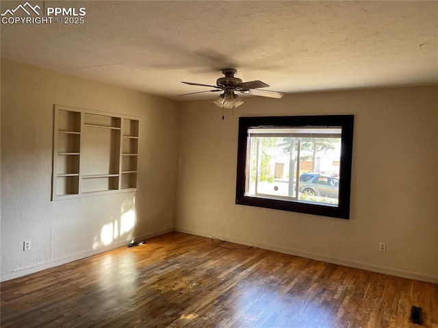 unfurnished room featuring a ceiling fan, a textured ceiling, baseboards, and wood finished floors