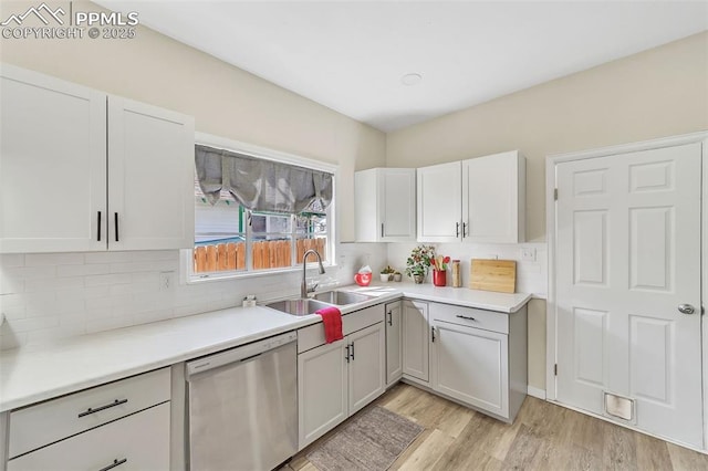909 E 10th St, Pueblo, CO 81001 - kitchen featuring light wood finished floors, light countertops, backsplash, stainless steel dishwasher, and a sink