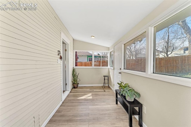 909 E 10th St, Pueblo, CO 81001 - corridor featuring vaulted ceiling, wooden walls, baseboards, and wood finished floors