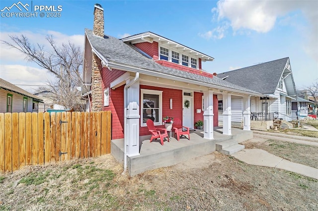 909 E 10th St, Pueblo, CO 81001 - view of front of property with covered porch, roof with shingles, fence, and a chimney