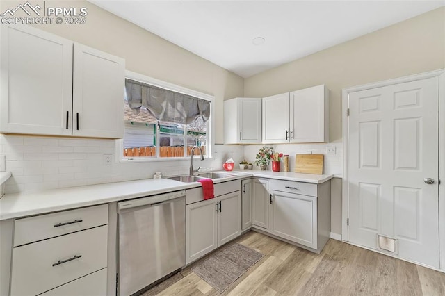 909 E 10th St, Pueblo, CO 81001 - kitchen featuring a sink, light wood-style floors, backsplash, and dishwasher