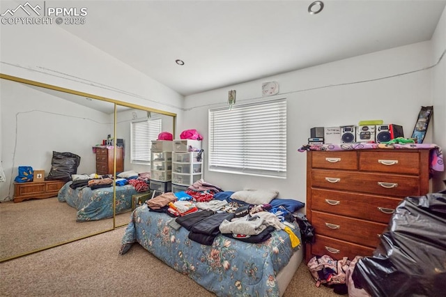 carpeted bedroom with a closet and vaulted ceiling