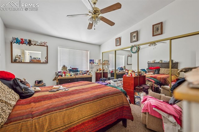 bedroom with ceiling fan, carpet, lofted ceiling, and multiple closets