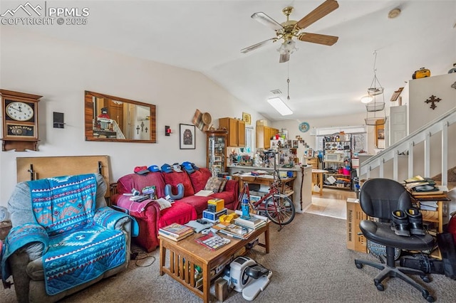 living area featuring stairway, a ceiling fan, and vaulted ceiling