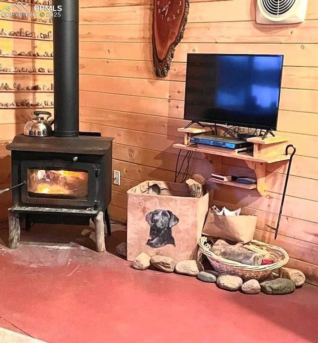 interior space with wooden walls, visible vents, and a wood stove