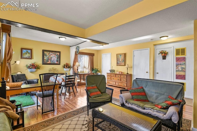 living area with a textured ceiling and wood finished floors