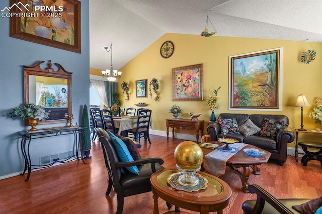 living area with a notable chandelier, baseboards, lofted ceiling, and wood finished floors