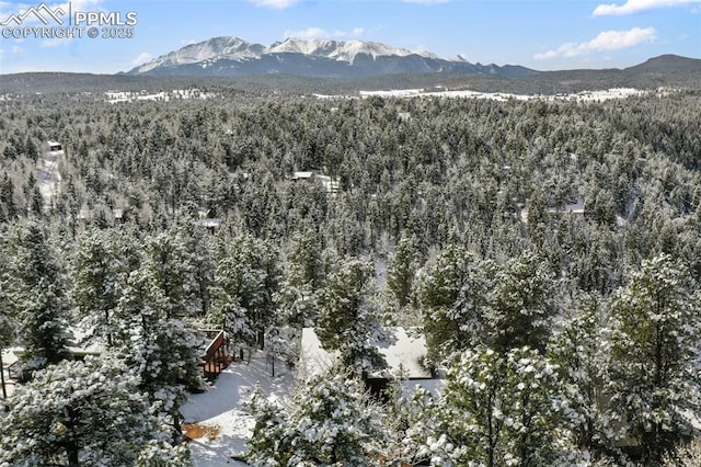 aerial view featuring a forest view and a mountain view