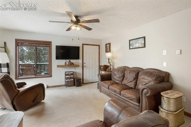carpeted living room featuring a textured ceiling, baseboards, and a ceiling fan