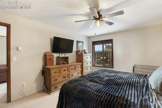bedroom featuring light carpet, ceiling fan, and a textured ceiling